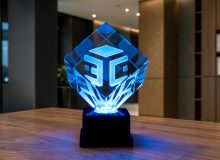 Награда из стекла «Куб 100» с 3D логотипом из геометрических форм и синей подсветкой